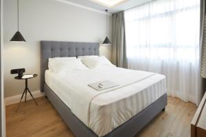雅典雅典艺术家酒店的卧室配有一张白色大床,上面有托盘