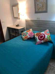 卡塞雷斯阿真蒂纳旅馆的一间卧室配有蓝色的床和两个枕头