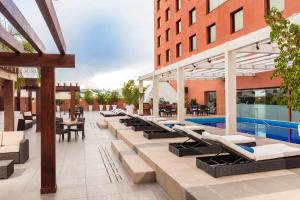 瓜达拉哈拉Barcelo Guadalajara的享有酒店外景,设有躺椅和游泳池
