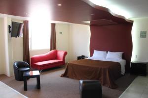 Acolman de NetzahualcóyotlMotel Septimo Eclipse的酒店客房,配有一张床和一张红色椅子