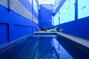 埃雷欣Blue Open Hotel的蓝色墙壁的建筑内的游泳池