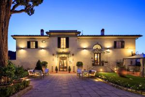 巴尼奥阿里波利Villa Il Sasso - Dimora d'Epoca的一间白色的大房子,晚上设有庭院