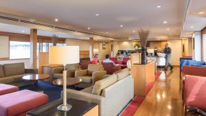 罗托鲁瓦罗托鲁阿千禧国际酒店的酒店大堂设有长沙发和桌子,可供住客使用