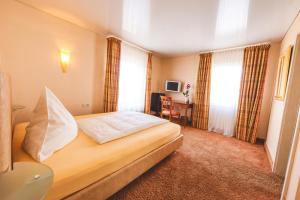 埃根斯泰因-列奥波德港Hotel Löwen的配有一张床和一张书桌的酒店客房