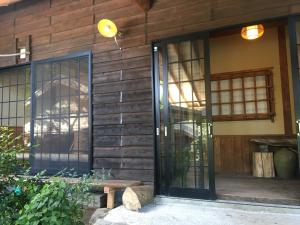 由布市山荘 紗羅樹 Syaranoki的木房子的入口,设有玻璃门
