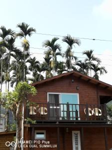 鹿谷乡溪头红瓣天民宿的带阳台和棕榈树的房子