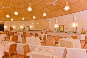 芭环礁马尔代夫梦乡度假村的宴会厅配有白色的桌椅