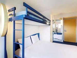 欧苏瓦地区普伊ibis Budget Pouilly-en-Auxois的一张蓝色双层床,位于带床的客房内