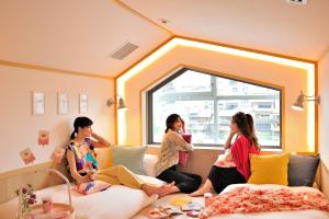 京都咖啡淘京都三条女士旅馆的三个女人坐在房间里的床边
