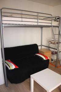 第戎Studio Dijon entre fac hopital et centre的配有双层床的客房内的一张黑色沙发