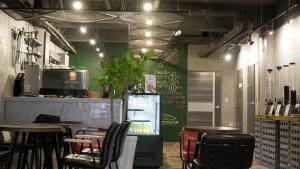 釜山釜山奥维旅馆的一间带桌椅和绿色墙壁的餐厅