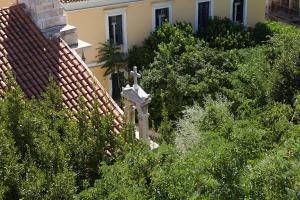 雅典雅典艺术家酒店的屋旁灌木丛中的十字架