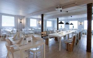 BergNorthern Light Hotell/Camp Steinfjord的餐厅设有白色的桌椅和窗户。