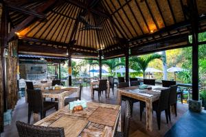 蓝梦岛桑兰邦吉海滩小屋酒店的户外餐厅设有木桌和椅子