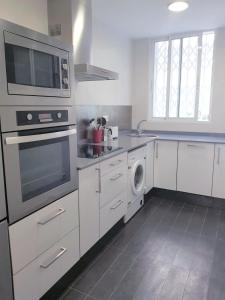 瓦伦西亚FLORIT FLATS - The Jardines del Turia Apartment的厨房配有微波炉和洗碗机。