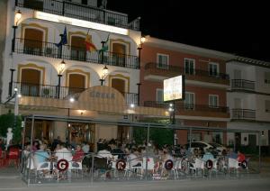 波索阿尔孔Hostal Restaurante Grela的一群坐在大楼前桌旁的人