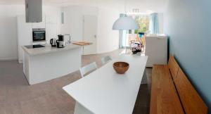 卡尔斯哈根Lotsenstieg 2 Kajuete 05的厨房配有白色的柜台和桌上的碗