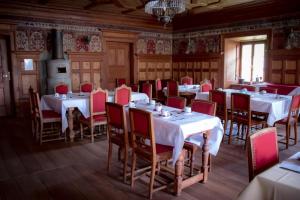 格雷索拉特里尼泰Hotel La Villa della Regina的用餐室配有白色的桌子和红色的椅子