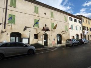 阿夏诺" Il Bersagliere " Dependance Hotel la Pace的2辆汽车停在一座带绿色百叶窗的建筑前