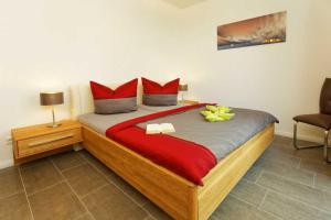 卡尔斯哈根Kapitaensweg 2 Kajuete 04的一间卧室配有一张带红色枕头的大床