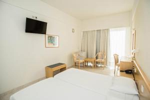 罗德镇里维埃拉酒店的酒店客房设有两张床和一张桌子。