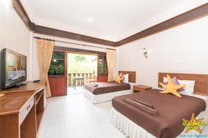 涛岛Asia Divers Resort的酒店客房设有两张床和一台平面电视。