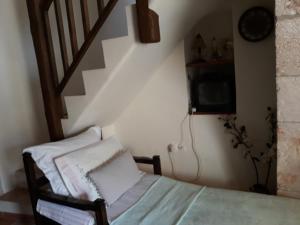赫索尼索斯Koutouloufari Cosy Cretan Cottage的客房设有一张床和带电视的楼梯
