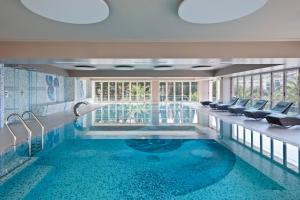 佩特罗瓦纳莫鲁Hotel AMI Budva Petrovac的游泳池,酒店内设有椅子和游泳池