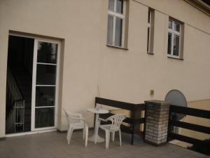 布拉格汉斯普卡膳食公寓的一座带两把椅子和一张桌子的庭院以及一座建筑