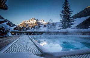 卡纳泽伊Hotel Cirelle Suite & Spa的山前的雪覆盖的热水浴池