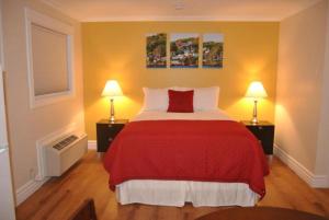 Arnold's Cove阿诺德湾酒店的一间卧室配有一张红色的床和两盏灯。