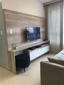 马塞约Apto Promenade I PONTA VERDE的客厅设有壁挂式平面电视。