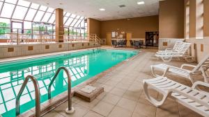 沃特敦贝斯维斯特水城/鼓堡酒店的一个带椅子和桌子的大型游泳池