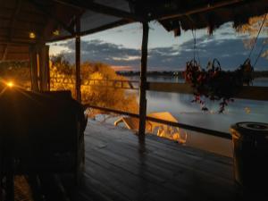 卡蒂马穆利洛Caprivi Houseboat Safari Lodge的从湖景房子的门廊上欣赏美景