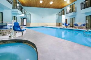 阿尔伯克基西阿尔伯克尔基戴斯酒店的大楼内一个带蓝色椅子的游泳池