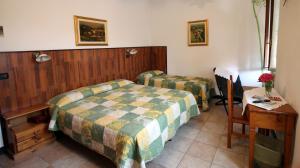 Molini di TrioraAlbergo Santo Spirito的一间卧室配有两张床、一张桌子和一张书桌