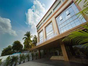 钦奈ST Parklane Airport Hotel Chennai的一座棕榈树建筑