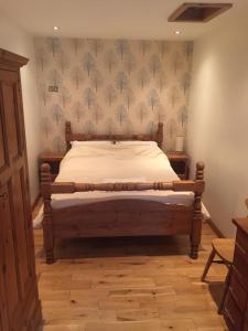 曼彻斯特The Old Vicarage Lodge的一间卧室配有一张木框床和壁纸
