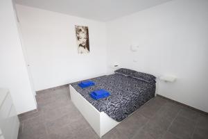 科拉雷侯Sol y Mar的小房间,配有一张带两张蓝色椅子的床
