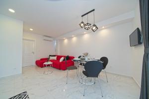 斯顿Apartment Marangun的客厅配有红色的沙发和桌子