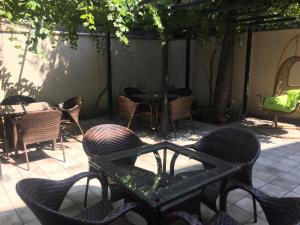 第比利斯伊比利亚迪杜贝酒店的户外庭院配有桌椅和桌子。