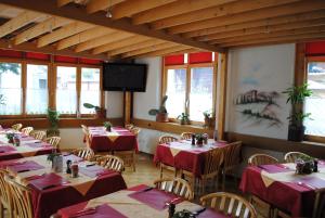 茨韦西门Post Hotel Vista的餐厅配有桌椅和红色桌布