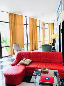 克瓦雷利Green House的客厅配有红色的沙发和桌子
