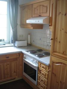 阿伦斯霍普Haus Achtern的厨房配有木制橱柜和炉灶烤箱。