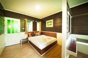 夜功府哈萨塔拉度假村的卧室配有一张床铺,位于带木墙的房间内