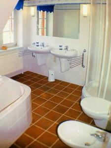 阿伦斯霍普Haus Achtern的浴室配有2个盥洗盆、卫生间和浴缸。