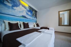 莫斯塔尔奥拉汽车旅馆的酒店客房设有两张床,墙上挂有绘画作品