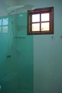 瓜鲁雅Pousada da Ju的带淋浴的浴室和窗户。