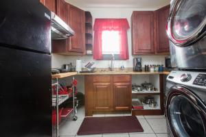 新奥尔良Perfect NOLA Hideaway的厨房配有木制橱柜和黑色冰箱。