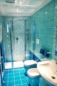 圣雷莫Maison Beaux-Arts的蓝色瓷砖浴室设有卫生间和淋浴。